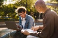 Two young stylish students doing homework with laptop and books Royalty Free Stock Photo