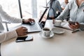 Two young successful designers are sitting with a laptop with a notepad discussing a creative project and drinking coffee Royalty Free Stock Photo