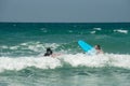 Two young surfer girls riding the waves