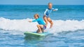 Two young surfers ride with fun on one surfboard Royalty Free Stock Photo