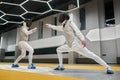 Two young swordsmen in uniform practicing attack and defense during training