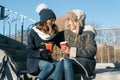 Two young teenage girls having fun outdoors, girlfriends in winter clothes, positive people and friendship concept. Girls drinking Royalty Free Stock Photo