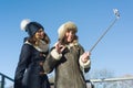 Two young teenage girls having fun outdoors, happy smiling girlfriends in winter clothes taking selfie, positive people and friend Royalty Free Stock Photo