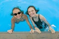 Two young teenage girls having fun in the swimming pool. Royalty Free Stock Photo