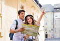 Two young tourists with map and camera in the old town Royalty Free Stock Photo