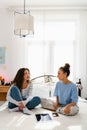 Two young girls talking while sitting on bed Royalty Free Stock Photo