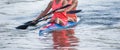 Two young woman athletes on rowing kayak on lake during competition