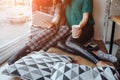 Two young woman chatting in a coffee shop. Two friends enjoying coffee together. One girl uses a tablet Royalty Free Stock Photo