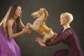 Two young woman dancing with antique carousel horse. Royalty Free Stock Photo