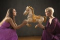 Two young woman dancing with antique carousel horse. Royalty Free Stock Photo