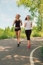 Two young woman doing sports outdoors in a park on sunny summer Royalty Free Stock Photo