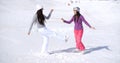 Two young woman frolicking in winter snow Royalty Free Stock Photo