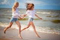 Two young woman running and having fun on the beach Royalty Free Stock Photo