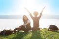 Two young woman sitting on mountain top and contemplating landscape Royalty Free Stock Photo