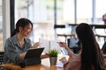 Two young woman talking about new project and sharing ideas. Royalty Free Stock Photo