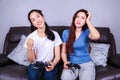 Two young woman using joystick controller playing video game on Royalty Free Stock Photo