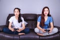 Two young woman using joystick controller playing video game on Royalty Free Stock Photo