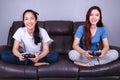 Two young woman using joystick controller playing video game on Royalty Free Stock Photo