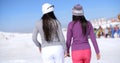 Two young woman walking in a winter ski resort Royalty Free Stock Photo