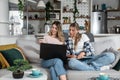 Two young women and best friends doing online shopping at home with a laptop and a credit card from web shop page sale while they Royalty Free Stock Photo