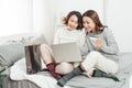 Two young women and best friends doing some online shopping at home with a laptop and a credit card Royalty Free Stock Photo