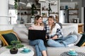 Two young women and best friends doing some online shopping at home with a laptop and a credit card from online web shop sale Royalty Free Stock Photo