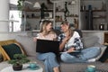 Two young women and best friends doing some online shopping at home with a laptop and a credit card from online web shop sale Royalty Free Stock Photo