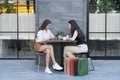 Two young women best friends smiling using a mobile phone. Female working with tablet using social network. Woman and shopping bag Royalty Free Stock Photo