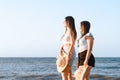 two young women in bikinis standing next to each other on the beach Royalty Free Stock Photo