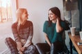 Two young woman chatting in a coffee shop. Two friends enjoying coffee together. Royalty Free Stock Photo