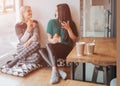 Two young woman chatting in a coffee shop. Two friends enjoying coffee together. Royalty Free Stock Photo