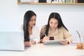 Two women colleagues sitting at desk talking about project startup ideas and discussing growth strategy in office. Royalty Free Stock Photo