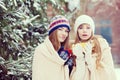 Two young women with colorful cups dring tea outdoor