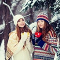 Two young women with colorful cups drinking tea outdoor and smiling Royalty Free Stock Photo