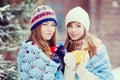 Two young women with colorful cups drinking tea outdoor and smiling Royalty Free Stock Photo