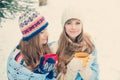 Two young women with colorful cups drinking tea outdoor and smiling Royalty Free Stock Photo