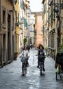 Two young women cycling in Lucca, Italy