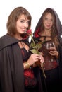 Two young women in disguise halloween with a glass of blood and