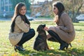 Two Young Women with a dog in the autumn park Royalty Free Stock Photo