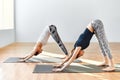 Two young women doing yoga asana Downward Facing Dog Royalty Free Stock Photo