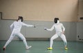 Two young women fencers having a training at the gym