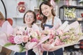 Two young women florist partners giving floral bunch with a happy smile Royalty Free Stock Photo