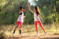 Two young women in the nature do stretching before fitness and make the gesture of give me five
