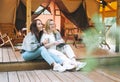 Two young women friends drinking tea and relaxing in glamping in the woods Royalty Free Stock Photo