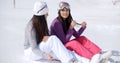 Two young women friends relaxing in the snow Royalty Free Stock Photo
