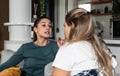 Two young women friends, roommates, business partners and owners of a small business are arguing at home due to the inappropriate Royalty Free Stock Photo