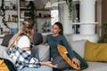 Two young women friends, roommates, business partners and owners of a small business are arguing at home due to the inappropriate