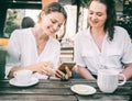 Two young women friends are sitting in a cafe drinking coffee and discussing the news, joyful and happy coffee break Royalty Free Stock Photo