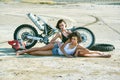 Two young women have fun playing on a disassembled motorcycle