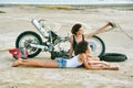 Two young women have fun playing on a disassembled motorcycle
